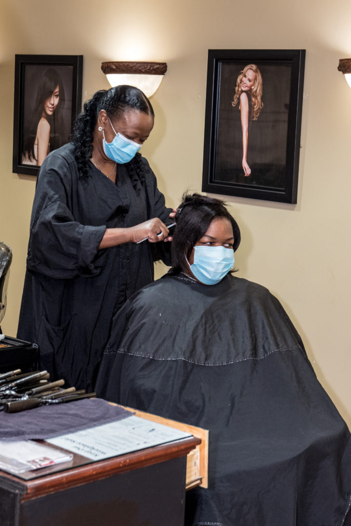 tall dark hair woman working on her clients hair