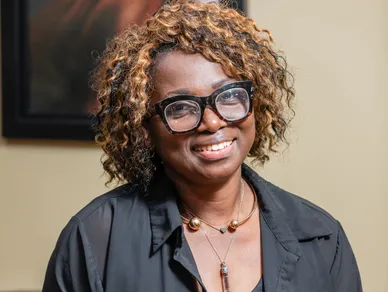 Woman photo with curly hair, glasses and black shirt